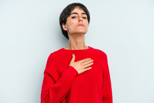 Young Caucasian Woman With A Short Hair Cut Isolated Taking An Oath, Putting Hand On Chest.