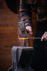 Man striking hot iron with a hammer on the Anvil © Dan Lambert Photography/Wirestock Creators
