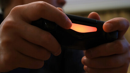 Close-up of fingers pressing on joystick. Concept. Men's fingers with excitement click on buttons of black game joystick with neon illumination