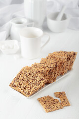 Crackers with sunflower seeds and flax seeds on a white table.