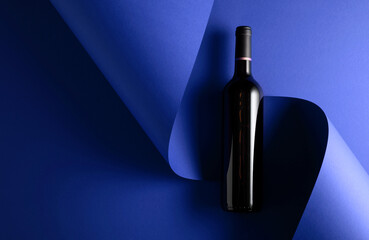 Bottle of red wine on a blue background.
