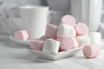 Pink and white marshmallows on a white table.