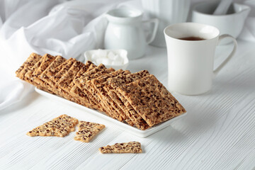 Crackers with sunflower seeds and flax seeds on a white table.