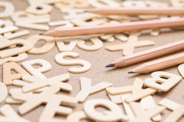 Closeup pencil on the pile of wooden English alphabets, learning English, writing or communication concept