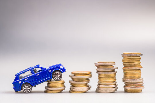 Small Blue Car Driving Up On The Stack Of Money, Financial Status For Buying A New Car, Car Leasing, Down Payment And Installments In The Long Term, Car Insurance Concept