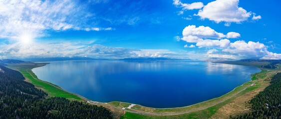 Aerial panoramic view of the Sayram Lake in China against blue cloudy sky background