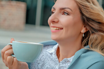 girl drinking coffee on the street. a cup of coffee. a cup of coffee and a girl's face close-up.