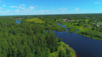 Fototapeta na wymiar Natural landscape with green trees, wide river, and green field. Shot. Aerial view of summer landscape with forest, green meadows and river in countryside, aero adventure in a summertime.