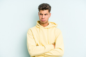 Obraz premium Young caucasian man isolated on blue background tired of a repetitive task.