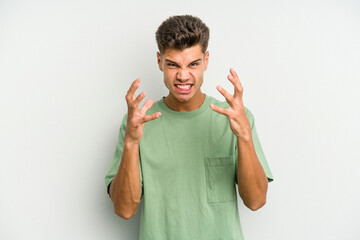 Fototapeta premium Young caucasian man isolated on white background upset screaming with tense hands.