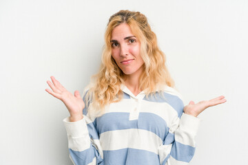Young caucasian woman isolated on white background doubting and shrugging shoulders in questioning...