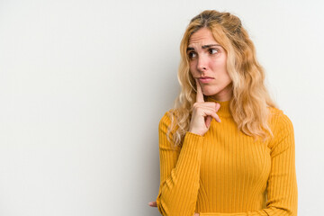 Young caucasian woman isolated on white background looking sideways with doubtful and skeptical expression.