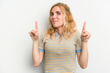 Young caucasian woman isolated on white background indicates with both fore fingers up showing a...