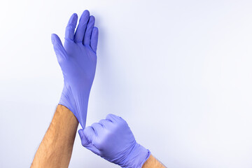 two human hands in blue nitrile surgical gloves, professional medical safety and hygiene for surgery and medical examination on a white background. Lots of empty space - obrazy, fototapety, plakaty