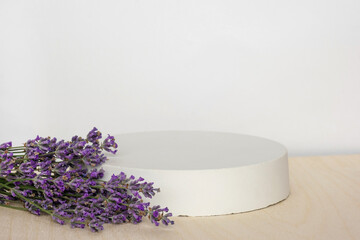 Podium for presentation on wooden table, lavender flowers. Abstract geometrical form. Cylinder...