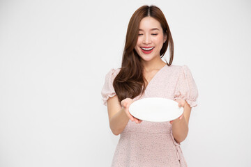 Young Asian woman holding and looking at empty white plate or dish isolated on white background