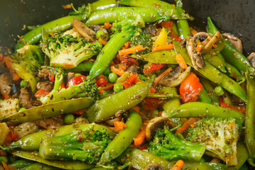 Stewed vegetables broccoli tomatoes and green peas with close-up.