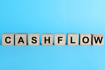 Wooden cubes with phrase Cash FLow on turquoise background