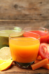 Delicious vegetable juices and fresh ingredients on wooden table