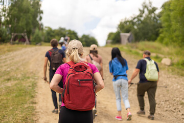 Group of hikers with backpacks climbing up mountains