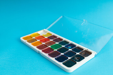 Brushes, painting tools and paints on a blue background