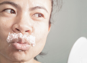 image of woman removing excess hair on my own face by using a cream that is a hair removal product...