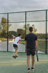 Título: young sportsman playing paddle tennis in an outdoor court.