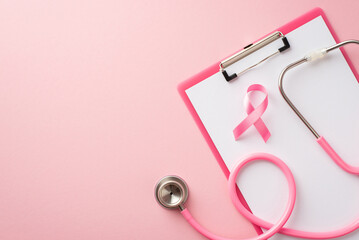 Top view photo of pink ribbon symbol of breast cancer awareness on clipboard and stethoscope on...