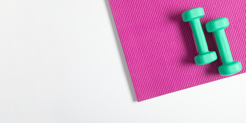 Yoga mat and dumbbells on white background. Healthy lifestyle. Flat lay, top view, copy space 