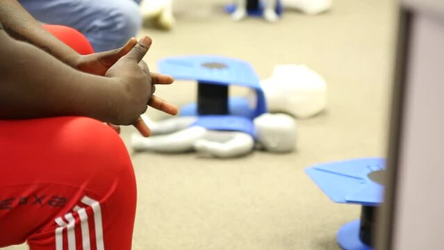 Staff practicing first aid cpr with AED machine and dummy dolls