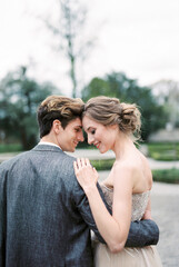 Bride and groom embrace in the park. Portrait