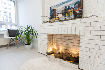 Fireplace on white brick wall in bright empty living room interior of house.