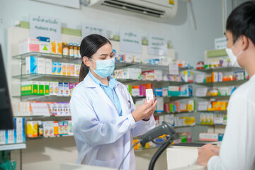 Portrait of female pharmacist wearing face mask in a modern pharmacy drugstore.