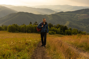 Young man enjoying the view on the top of the mountain. Carpathian mountains, Ukraine