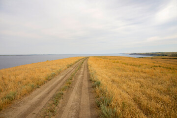 dirt road leading to the edge of a cliff above the water