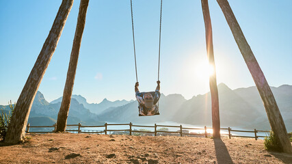 Man swinging on a giant wooden swing. Biggest swing of Leon in Riaño, in the nature.