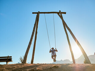 Man swinging on a giant wooden swing. Biggest swing of Leon in Riaño, in the nature.