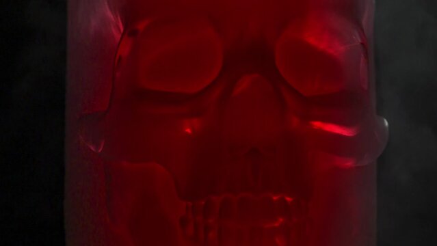 X-RAY Style Red Skull. Frosted red glass skull rotates slowly in icy vapors against black background