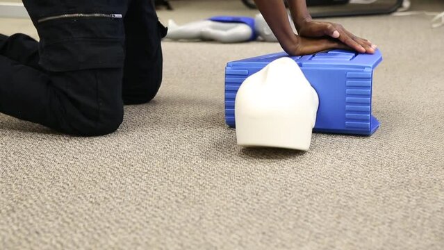 Staff practicing first aid cpr with AED machine and dummy dolls