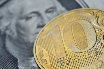 Russian coins of 10 rubles face value lie on the American, paper dollar.