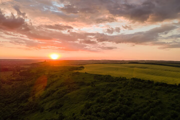 Obraz premium Aerial landscape view of yellow cultivated agricultural field with ripe wheat on vibrant summer evening