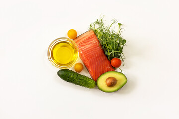 Ingredients of healthy food. Fish, micro green pea sprouts, olive oil, cucumber, tomato, avocado. Ketogenic low carbs diet concept.