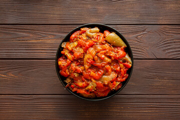 Autumn vegetable stew on brown wooden background, top view. 
