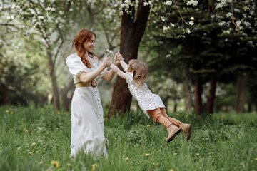 Mom and little daughter in the apple orchard