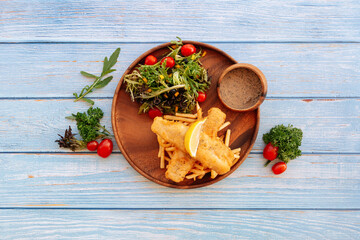 Valle Black Pepper Cod Fish And Chips with salad, lime and cherry tomato Served in dish isolated on wooden table top view fastfood