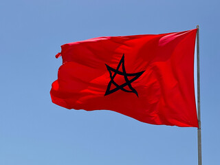 Moroccan flag fluttering with blue sky in the background	