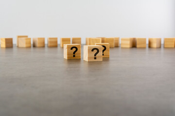 cube with question mark on wooden background. space for text