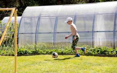 boy playing football in summer cottage