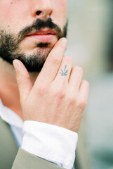 Man with a beard touches his chin with his fingers. Close-up