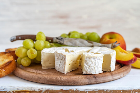 Brie cheese for Mediterranean breakfast on wooden background.
